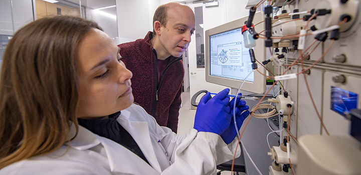 a man and woman in lab using equipment